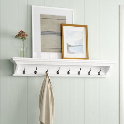 Add extra storage to your entryway or mudroom with this 8-hook coat rack. It's made from solid kiln-dried mahogany wood in a crisp white finish with crown molding that complements Sand & Stable™ decor. The eight C-shape hooks offer just enough space for dog leashes, coats, and scarves. Plus, a small shelf above the crown molding gives you a spot to keep decorative objects or potted plants. This coat rack measures 51.18" wide, and is meant to be installed right on to your walls. | Sand & Fabric Finishes, Walls Color, Coat Rack With Storage, Wall Hook Rack, Small Shelf, Entryway Wall, Crown Moulding, Hook Wall, Business Decor