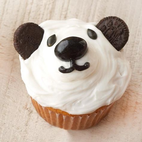 These pandas don't do kung fu, but these birthday cupcakes are as charming as a movie character or a favorite stuffed toy. Plus, they're so easy to decorate. 1. Frost the top of a cupcake with white decorating frosting. Split miniature chocolate sandwich cookies in half, discarding filling; press cookie halves into frosting for ears. 2. Arrange a black jelly bean and black candy-coated sunflower kernels on cupcake for nose and eyes. Pipe black icing for mouth. Panda Cupcake, Cupcakes For Kids, Panda Cupcakes, Birthday Cupcakes Boy, Class Treats, Creamy Frosting, Kid Surprise, Animal Birthday Cakes, White Cupcakes