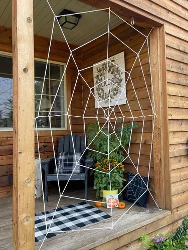 DIY Giant Spider Web Halloween Decoration Making A Spider Web With Yarn, Halloween Web Decorations, Spider Webs Halloween Decoration, Giant Spider Halloween Diy Pool Noodles, Quick Halloween Decorations, How To Make A Spider Web With Yarn, Spider Porch Decorations, Diy Front Porch Halloween Decorations, Diy Giant Spider Web