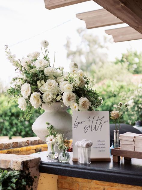 Potted Greenery Wedding, Large White Centerpiece Wedding, Wedding Flower Pots Outdoor, White Rose Ranunculus Bouquet, Large Vase With Greenery, Low White Centerpiece Wedding, Ranunculus Table Arrangement, Bar Flower Arrangement Wedding, Wedding Bar Flower Arrangement