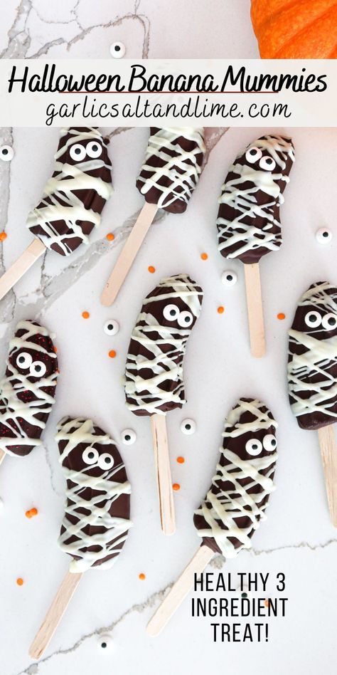 Banana mummies arranged on a white countertop. Ghost Banana Pops, Mummy Pretzels Rods, Halloween Treats With Marshmallows, Daycare Halloween Party Food, Adult Halloween Treats To Hand Out, Banana Halloween Treats, Halloween Toddler Meals, Halloween Snacks Fruit, Halloween Bat Treats