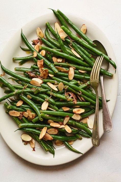 This recipe for green beans almondine combines tender crisp green beans with caramelized shallots, sliced almonds and fresh parsley. It’s a delicious side dish simple enough for a weeknight dinner, but fancy enough for a holiday meal! Green Beans With Shallots, Thanksgiving Green Beans, Delicious Dinner Ideas, Green Beans With Almonds, Green Beans Almondine, Blanching Green Beans, Easy Green Beans, Caramelized Shallots, Lemon Green Beans