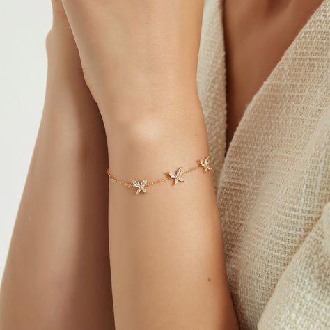 This triple butterfly bracelet is crafted from 18k gold vermeil, which is a thick layer of 18k gold over sterling silver. This gives the bracelet a luxurious and lustrous appearance while also providing durability. The centerpiece of the bracelet is the three butterfly charms that are attached to it. Each charm is meticulously designed to look like a butterfly, with delicate wings and intricate detailing. The charms are made with high-quality cubic zirconia (CZ) stones that sparkle and shine like diamonds, adding a touch of glamour to the bracelet. Material : 18k Gold Vermeil Length : 6.5" Extension : 1" Gemstones : Cubic Zirconia Bracelet Ideas Gold, Butterfly Bracelet Gold, Simple Jewelry Earrings, Braclets Gold, 3 Daughters, Delicate Gold Bracelet, 3 Best Friends, Gold Bracelet Simple, Neck Pieces Jewelry