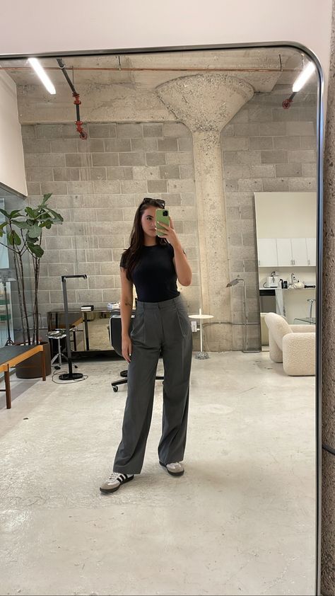 Brunette woman taking a mirror selfie of her outfit in a minder studio space. She’s wearing a black skims fitted t shirt, grey trousers, and adidas samba sneakers. Sambas Adidas Outfit, Trendy Sneakers For Women, Adidas Samba Outfit Women, Sambas Adidas Women Outfit, Outfits With Baggy Jeans, Adidas Samba Women, Samba Adidas Outfit, Adidas Gazelle Outfit, Samba Outfit Ideas