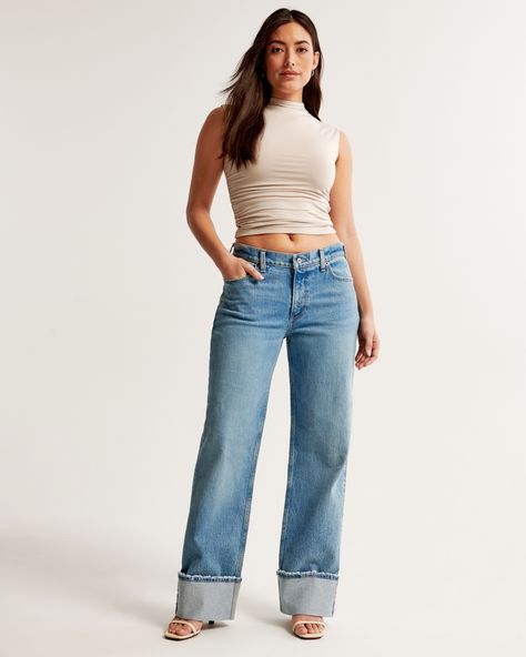 Our Curve Love low rise baggy jeans in a medium wash with a cuffed hem. This fit features a 8.5” low rise, is slightly relaxed at waist and hips, and eases at the thigh into a baggy, full-length leg shape. We recommend buying your true size for a baggier fit. Size down for a closer fit. The viral fit that eliminates waist gap: Curve Love features additional room through the hip and thigh for curve-hugging comfort. This jean is made from our vintage stretch fabric which features both an authentic Abercrombie And Fitch Outfit, Low Rise Baggy Jeans, Baggy Jean, Abercrombie Jeans, Cuffed Jeans, Love Jeans, Stretchy Jeans, Jeans For Short Women, Baggy Jeans