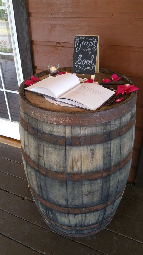 Guestbook on top of one of our wine barrels. Barrel Decor Wedding, Lanterns On Wine Barrels Wedding, Barrel Top Guest Book, Barrel Wedding Decor Entrance, Wedding Bar Wine Barrels, Whiskey Barrel Wedding Guest Book, Barrel Wedding Decor, Wedding Welcome Sign Wine Barrel, Pallet Backdrop