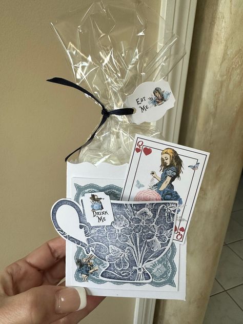 This set of 6 Fill My Teacup Navy Blue and Silver Alice in Wonderland tea party favors is perfect to fill with your own teabags! The trick is tipping your tea bag upside down, folding the bottom half of the teabag and stuffing the bottom half into the tea cup. Slightly shake the tea party favor to allow the loose tea to fill the bottom half of the teabag in the teacup. Voilà! Stuff the bag with sweets and treats! Whether it’s edible candy or cookies, everyone will follow the directions “Eat Me!” This box is approximately 3.5”x3.18”x2.25” and can store three to four medium cookies or many candies for your partygoers! Price does includes 6 favor boxes, 6 tags, 6 plastic bags and 6 ribbons. Ribbon may vary due to availability. The silver teacup is handstamped, and heat embossed for a raised t Alice In Wonderland Adult Party, Dit Gifts, Alice In Wonderland Eat Me, Tea Party Favor, Edible Candy, Alice In Wonderland Crafts, Alice In Wonderland Birthday Party, Bridal Party Invitations, Wonderland Events