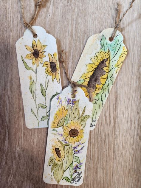 Sunflower Autumn Watercolor Book Markers Set, Journals Tags Hand Painted Book Markers, Reader Gift. Set of 3 The front side is hand painted watercolor sunflowers. The back side has area for  writing a note. Signed by the artist Shirley Ann Galster.  Painted on watercolor paper 140 lb. Natural white, cold pressed paper. Acid free. Each tied on the top with a jute cord. Measures 2 in. x 5in. The watercolor Bookmarkers are finished with a wax medium (waterproof).  Book Markers are shipped in a clear plastic sleeve Great for journals or a  gift for  book lover, a friend or yourself. Shirley Ann Galster Watercolor Bookmarkers, Sunflower Bookmark, Sunflower Autumn, Appleton Wisconsin, Watercolor Sunflowers, Autumn Watercolor, Paintings Ideas, Pressed Paper, Gift For Book Lover