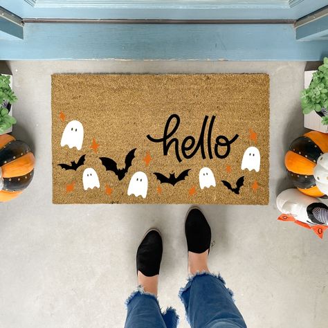 Welcome the spooky season with our charming handmade Halloween Doormat! This delightful doormat features a playful pattern of friendly ghosts, fluttering bats, and vibrant orange stars, all set against a backdrop that perfectly complements the bold "hello" text.  ✦Production time is 5-7 business days before shipping. Shipping is UPS Ground or USPS service. No PO Boxes, please. ✦All our coir welcome mats are natural brown in color. Minor variations are normal. ✦Each original design is available i Spooky Rugs Diy, Sip And Paint Halloween Door Mat, Door Mat Painting Diy Halloween, Door Mat Ideas Halloween, Halloween Door Mat Party, Painting Door Mats Diy Halloween, Pumpkin Door Mat, Halloween Outdoor Mat, Fall Mats Diy