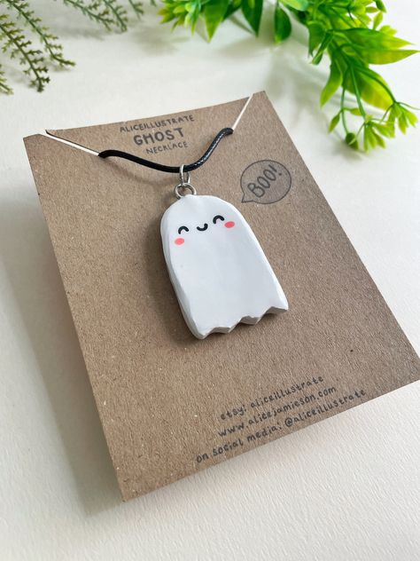 Spooky Cute Ghost Pendant! This listing is for ONE necklace with a handmade and hand-painted Ghost clay pendant that's perfect for making any outfit a little more cute or for gifting jewellery to a fan of Halloween and Ghosts! + + + + + + + + + + + + + + + + + + + + + + + The Ghost pendant on this necklace is handmade using air-drying clay that is PVC free to be friendlier for the environment. Painted and then sealed with a shiny Resin glaze, this necklace is ready to accompany you on the quest that is life! The necklace is made of black wax rope, which is lightweight, smooth and flexible. Clasp and extension chain are made of metal. The pendant measures approx. 3cm wide and 4.25cm tall. The necklace chain measures 42cm, but can be made to be 46cm with the use of the extender chain. The ne Clay Chain Necklace, Halloween Clay Pins, Air Dry Clay Necklace Pendants, Halloween Clay Charms, Halloween Air Dry Clay, Air Dry Clay Pendants, Ghost Clay, Painted Ghost, Kawaii Ghost