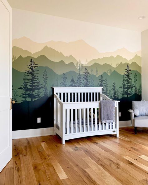 This little boys room boasts cool wallpapers for boys with green mountain mural. A white spindle crib with gray bedding stands in front of the accent wall on stained wood flooring. Cool Wallpapers For Boys, Wallpapers For Boys, Creative Accent Wall Ideas, Creative Accent Wall, Boys Room Mural, Farm Hacks, Nursery Decor Ideas, Trunk Or Treat Ideas, Taupe Walls