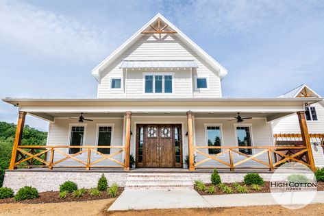 Farmhouse with custom wood railing, stamped concrete porch floors, tounge and groove ceiling Farmhouse Concrete Porch, Front Porch Rails Ideas Farmhouse, Stained Wood Porch Railings, White Farmhouse Porch Railing, Farmhouse Porch With Railing, Wrap Around Porch Railing Farmhouse, Concrete Porch Railing Ideas, Wood Beams Front Porch Farmhouse, Farmhouse Porch Railing Wood