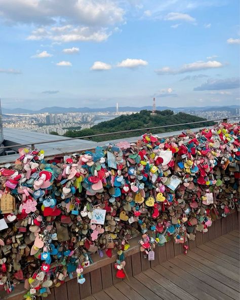 💖🔒✨ Love is in the air at the Love Lock Bridge by Namsan Tower! ✨🔒💖 This magical spot is a must-visit for anyone in Seoul! Couples and friends alike come to attach their love locks, symbolizing their unbreakable bonds. The views of the city from here are absolutely breathtaking! 🌆❤️ Walking along the bridge surrounded by colorful locks and heartfelt messages makes for such a romantic experience. Whether you’re with your special someone or exploring solo, the vibes here are simply enchanting... Korean Namsan Tower, South Korean Aesthetic, South Korea Trip, Love Lock Bridge, Namsan Tower, Lock Bridge, Love Locks, Korea Trip, Korean Picture