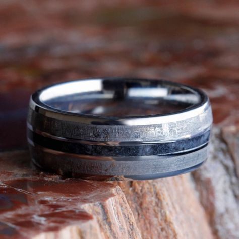 This mens meteorite wedding band has a dark inlay of crushed onyx between the gibeon meteorite. A titanium and meteorite ring is perfect for celebrating your vows.Astronomy jewelry attests to the magnificence that exists in our universe. This meteorite ring shows a fantastic Widmansttten pattern. It has been etched with an acid to reveal the characteristic patterns, or Widmansttten figures, of iron meteorites. No two etched meteorites will have the exact same pattern, making your wedding band a Mens Wedding Rings Vintage, Meteorite Engagement Ring, Meteorite Rings, Astronomy Jewelry, Meteorite Wedding Band, Band Ideas, Meteorite Jewelry, Titanium Rings For Men, Gemstone Wedding Rings