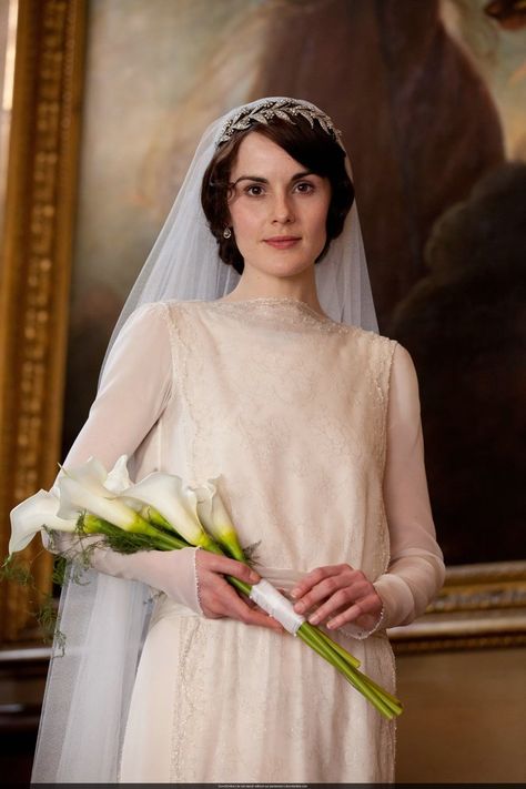 Ah, the royals!  Lady Mary carried a simple bouquet of several long-stemmed white Calla lilies with greenery, tied together with white ribbon and pearl-headed pins. Any florist should be able to create a similar arrangement for you, and DIY brides can also put it together quite easily the morning of their wedding. Downton Abbey Characters, Downton Abbey Wedding, Mary Crawley, Lady Mary Crawley, Downton Abbey Series, Bridal Crown Tiara, Downton Abbey Fashion, Downton Abby, Michelle Dockery