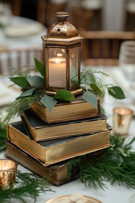 Elevate your wedding or special event with charming book centerpieces! Explore decor ideas that incorporate vintage books, flowers, and candles to create a whimsical and elegant atmosphere. Ideal for graduations, baby showers, and more, these centerpieces will captivate your guests and add a personal touch to your celebration. Book And Candle Wedding Centerpieces, Diy Book Centerpieces, Lantern Flowers Wedding, Farewell Party Centerpieces, Book Table Centerpieces, Vintage Lantern Wedding Decor, Cloche Wedding Centerpiece, Wedding Table Placement Ideas, Book Party Centerpieces