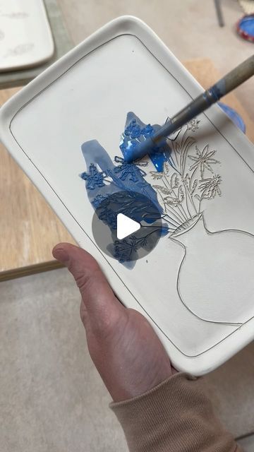 Jenna Vanden Brink Ceramics on Instagram: "Making of this little porcelain tray, from carving the leather-hard piece to pulling it out of the glaze kiln.  Couple things I like:  The carved texture that subtly remains under the clear glaze. It’s a lot of work to individually carve each piece but I think it makes it extra special, so I like that some evidence of the knife cuts remains.  The blue dots on the vase are a nod to my blueberry design 🫐🫐" Ceramic Glazing Ideas, Pottery Designs Carving, Sgrafitto Ceramics, Pottery Carving Ideas, Carving Ceramics, Blueberry Design, Carving Pottery, Blue Pottery Designs, Handbuilt Pottery