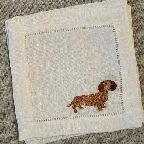 "A small, delightful dachshund is embroidered on classic white linen cocktail napkins.  Location: in the bottom right-hand corner or center of napkin.  Add optional personalization ( script or block font). Note that due to space limitations not all personalization can be accommodated. Set of 4 napkins  Details:  -100% linen  -approximately 6\"x6\" square with a 1\" hemstitch border, -embroidered with poly thread for durability.   Napkins are machine washable. Please line dry and iron on reverse Dog Embroidery Ideas, Embroidered Gifts Ideas, Embroidered Koozies, Sewing Napkins, Sausage Dog Embroidery, Embroidery Gift Ideas, Hand Embroidered Napkins, White Linen Cocktail, Dachshund Embroidery