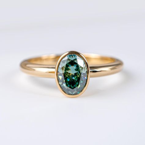 🌟 Introducing our newest addition: Oval Teal Green Moissanite Solitaire Bezel Ring! 💍 Crafted from solid 9ct yellow gold, this ring exudes elegance and sophistication. Each ring is hallmarked with full British assay marks and our own mark, guaranteeing its quality and authenticity. Available sizes: M and P 💎 Moissanites are renowned for their strength and durability, ensuring this ring will be cherished for a lifetime. DM me with any questions! Michael :) #MoissaniteRing #TealGreen #... Green Moissanite, Prong Engagement Rings, Bezel Set Engagement Ring, Green Oval, Bezel Ring, Rings Simple, Moissanite Rings, Teal Green, Bezel Setting