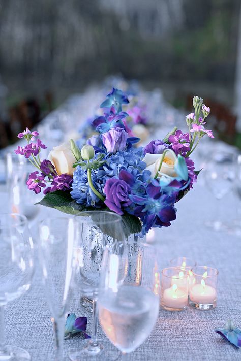 Blue and Purple Flower Centerpieces Blue Violet Wedding Theme, Blue Purple White Flower Arrangement, Blue Purple Party Decor, Blue Purple Fall Wedding, Purple Blue White Wedding Centerpieces, Purple And Blue Engagement Party, Purple Blue Gold Party Decorations, Purple Blue Centerpiece, Blue And Purple Reception Decor