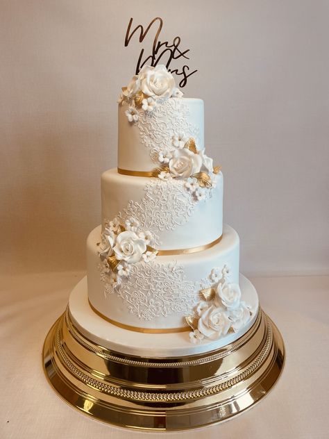 Amberley, popular 3 tier design decorated with edible lace detail and clusters of sugar flowers in white and gold, perfect for a festive Chrismas season wedding Wedding Cake Designs Gold And White, Cream And Gold Wedding Cake, 3 Tier Wedding Cakes Simple Elegant, 3 Tiers Wedding Cake, 3 Tier Wedding Cake White And Gold, Wedding Cakes With Gold Accents, Modern Two Tier Wedding Cake, Ivory And Gold Wedding Cake, Wedding Cakes White And Gold