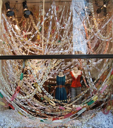 Hanging paper chains can look great.  Add colour to a plain background, match in with the colourscheme, be a cheap option for decoration.... Anthropologie Window Display, Winter Window Display, Anthropologie Display, Anthropologie Store, Anthropologie Christmas, Holiday Window Display, Window Display Retail, Anthropologie Holiday, Christmas Window Display