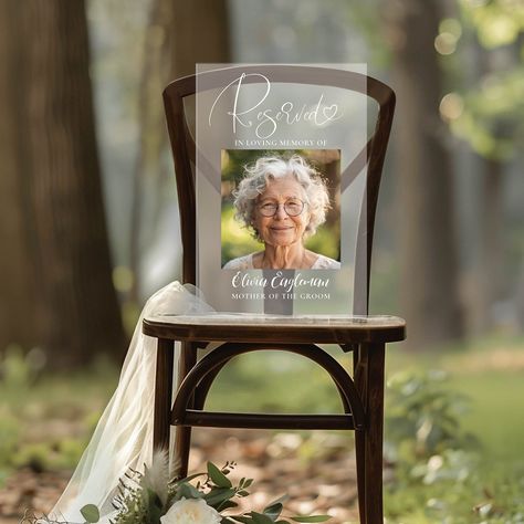 The "Reserved" Memorial Photo Sign is an ideal way to pay tribute to your loved ones on your wedding day. This customizable frosted acrylic plaque acts as both a heartfelt memorial and an elegant decor element. Perfect as a sympathy gift or wedding remembrance, it beautifully honors those who will always hold a special place in your heart. Remembering People At Wedding, Wedding For Passed Loved Ones, Memorial For Wedding Ideas, Wedding Memorial Seat Ideas, In Memory Of Signs For Wedding, Wedding Reception Memory Table, At Last Wedding Theme, Reserved In Memory Wedding Seat, In Loving Memory Ideas For Wedding