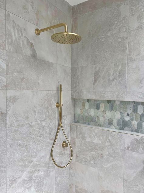 Rock Salt White Gold Tiles Bathroom, Bathroom Tile White And Brass, Rock Salt White Gold Tiles, Marble Shower With Brushed Brass Fixtures, Bathroom Tiles Stone Effect, White Gold Tile, Gold Shower Fixtures, Matte Marble Shower Walls With Pebble Shower Floor With Nickel Shower Head, Rock Floor