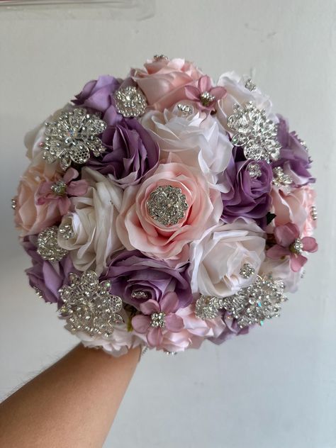 Handmade quinceañera bouquet made with lilac, blush and ivory artificial roses. Finished off with silver brooches. This bouquet does have extra brooches on it.  *Decor can be changed upon request* *This is a made to order bouquet*  *Please note brooches can change in style based on availability* Quinceanera Flowers, Delulu Era, Rose Gold Wedding Accessories, Quinceanera Bouquet, Ivory Bouquet, Designing Clothes, Random Products, Makeup Images, Pretty Quinceanera Dresses