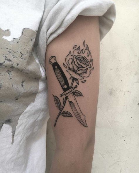 Knife and burning rose tattoo inked on the left upper arm Knife And Rose Tattoo, Rose Tattoo Stencil, Rose Tattoo Meaning, Tatuagem Masculina Pequena, Knife Tattoo, Omerta Tattoo, Skeleton Hand Tattoo, Fire Tattoo, Back Of Shoulder Tattoo