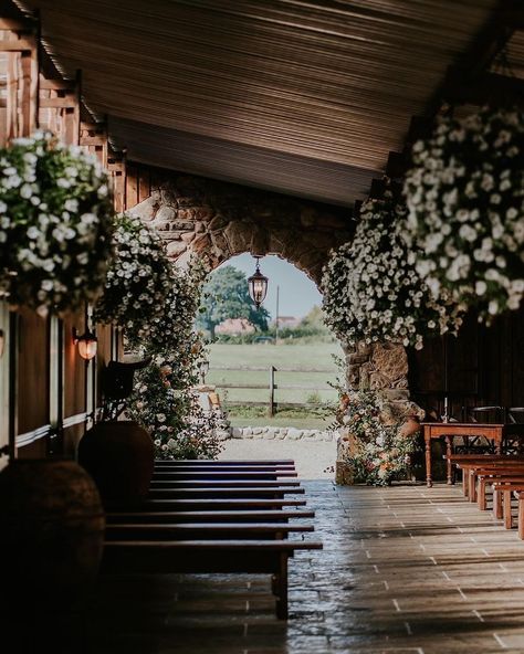 Inside/outside ceremony setting at the stables at The Willow Marsh Farm. Complete with flagstone floor, natural light, bench seating for wedding guests and lots of wild flowers. Willow Marsh Farm, Seating For Wedding, Flagstone Floor, Outside Ceremony, Iron Pergola, Farming Family, Farm Cafe, The Stables, Cottage Farm