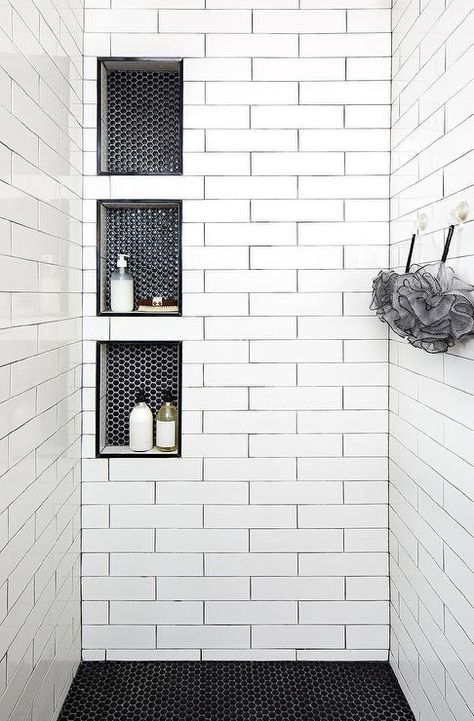 Triple stacked shower niches with black hexagon tiles surround long white shower tiles with black grout creating a unique and stylish walk-in shower design. White Shower Tile, Design Interior Baie, Black Grout, Decor Baie, Bad Inspiration, Interior Minimalista, 카페 인테리어 디자인, Shower Niche, Master Bath Remodel