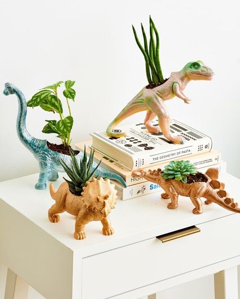 Those plastic dinosaur toys you used to play with as a kid make for adorable decorations, plant holders, book ends or jewelry holders. A coat of your favorite metallic paint and you're good to go! Dinosaur Bedroom Decor Ideas, Diy Dino Decor, Dinosaur Apartment, Dinosaur Diy Decor, Diy Dinosaur Decor, Dinosaur Planter, Dinosaur Diy, Dinosaur Decorations, Jewerly Holders