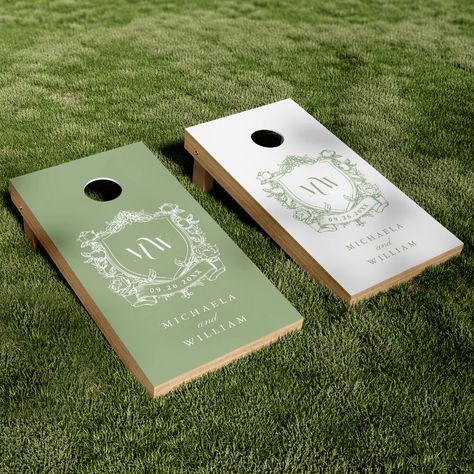 Celebrate love in the great outdoors with this elegant couple's crest cornhole set tailored for your wedding reception. This beautifully designed set offers a touch of nature's serenity mixed with the bespoke charm of personalized detailing, ideal for adding a refined outdoor element to your wedding reception or garden party. The set features two cornhole boards, each boasting a distinguished vintage regency style botanical crest that frames the couple's initials in a delicate modern font. One b Sage Outdoor Wedding, Outdoor Games For Wedding Reception, Green Plates Wedding, Custom Wedding Cornhole Boards, Unique Outdoor Wedding Ideas, Cornhole Boards Designs Wedding, Cornhole Board Wedding, Wedding Board Games, Wedding Corn Hole Boards