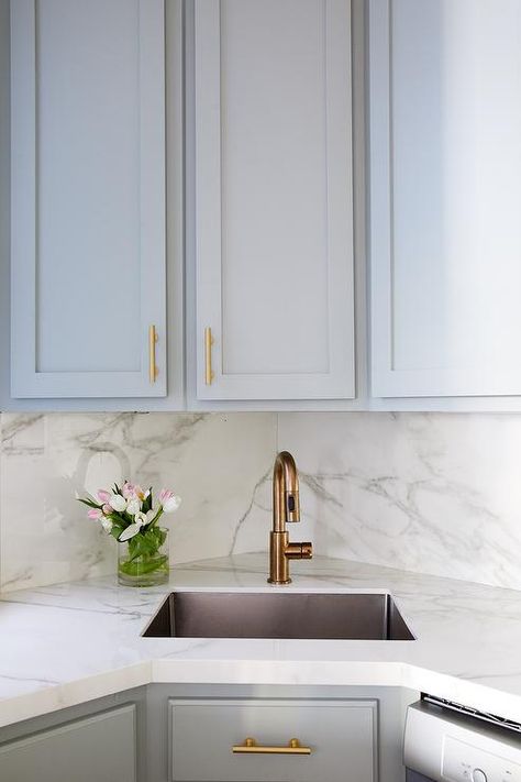 Small gray kitchen with a corner sink and a brass faucet finished with gray cabinets and a marble countertop. Small Gray Kitchen, Corner Kitchen Sink, Corner Sink Kitchen, Kitchen Sink Design, Condo Kitchen, Corner Sink, Gray Kitchen, White Marble Countertops, Kitchen Corner