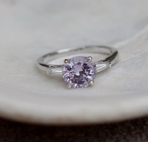 Lilac Sapphire engagement ring.This ring features a 2ct round Lilac sapphire. The stone is very beautiful and clean, tones of sparkles, like a diamond! The color is lilac with lavender and pink overtone.This beauty is set in a 14k white gold diamond setting, 2 baguette diamonds on the sides, TDW 0. Lavender Diamond Ring, Lilac Sapphire Engagement Ring, Lilac Wedding Ring, Lilac Engagement Ring, Lavender Engagement Ring, Lilac Ring, Lilac Sapphire, Round Sapphire Engagement Ring, Peach Sapphire Rings