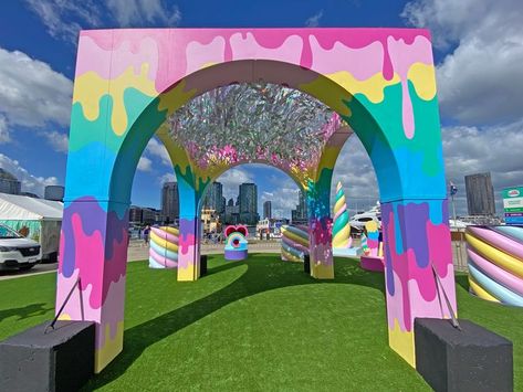 Rainbow coloured pavilion arches over the unicorn garden activation space, with reflective silver streamers hanging from the sky. Scenic painting of dripping rainbow colours adorn its columns. Created for the Unicorn Garden kids event at Docklands in Melbourne. Creative Ideas For Events, Arch Event Design, Corporate Event Entrance Arch Design, Event Arch Design, Burning Man Art Installation, Entrance Arch Design, Event Arch, Docklands Melbourne, Event Activations