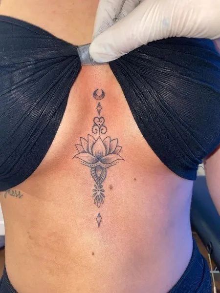 Tattoo Ideas On Sternum, Neck And Shoulder Tattoos Black Women, Sternum Tattoos Black Women, Women’s Underboob Tattoo, Lotus Flower Tattoo Between Breast, Underboob Lotus Tattoo, Lotus Flower Tattoo Under Breast, Womens Underboob Tattoo, Flower Between Breast Tattoo