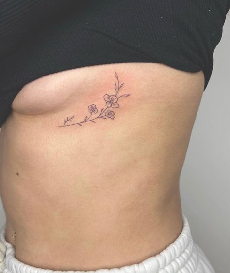 flower tattoo @chiko.tattoo Reinvent Yourself Tattoo, Dainty Flower Tattoos Rib, Cute Tattoos Under Breast, Hip Tatoos Woman, Collarbone Tattoo Flower, Rose Tattoo Spine, Collarbone Flower Tattoo, Mom Inspired Tattoos, Hideable Tattoos