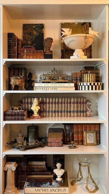 Antique & Vintage Home by Veronica Ashley on Instagram: "Style my vintage shelves with me ✨ It was time to transform my shelves back to a former version of themselves— with some updates, of course! Layering my own curated collection of vintage and antique treasures on these shelves gives me so much joy and I wanted to share that process with you. Stay tuned as I am back this week (and next) with lives sales lined up! So many more vintage and antique treasures to come. Follow along for more vintage and antique hauls, shop collections, live sales and more! ✨ Xx Veronica . . . . . #vintagedecor #shelfstyling #antiquelove #vintagehomedecor #onlinevintageshop #vintagehaul #shopvintage #curatedvintage #smallbusiness #vintageshop #antiquesofinstagram #estatesalefinds #thriftedandstyled #myc Bookshelf Ideas Vintage, Antique Shelf Decor Display, Wall Bookcase Decor, Victorian Shelf Decor, Antique Shelves Display Ideas, Vintage Bookcase Styling, Decorating Shelves With Antiques, How To Style Office Shelves, Antique Shelf Styling