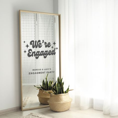 Make your engagement announcement uniquely yours with our Retro-Style 'We're Engaged' Vinyl Mirror Sign Sticker. Crafted in a cool and vintage-inspired font, this sticker adds a touch of nostalgia to your special moment. Perfect for mirrors, glass surfaces, or any smooth backdrop, this sticker is easy to apply and creates an eye-catching display.  Decal only *MIRROR/SIGN NOT INCLUDED* S I Z E S Extra Small - 30cm Width x 26.5cm Height Small - 40cm Width x 35.5cm Height Medium - 50cm Width x 44.5cm Height Large - 60cm Width x 53.5cm Height This decal can be cut into sections and arranged to best fit your surface. Please measure the mirror or board you are placing it on and select your size accordingly. It is your responsibility to make sure the size fits your desired destination. If you are Balloons For Engagement Party, At Home Engagement Decor, Engagement Party Ideas Decorations, Engagement Backdrop Ideas, Small Engagement Party, Engagement Party Backdrop, Fun Engagement Party, Vinyl Mirror, Engagement Party Decor