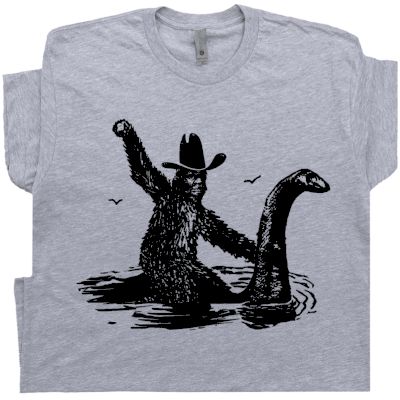 Bigfoot T Shirt | Sasquatch Riding Loch Ness Monster | Cryptozoology T Shirt Sasquatch Shirt, Bigfoot Humor, Loch Ness Monster, Funny Shirts For Men, Loch Ness, Novelty Shirts, Bold Logo, Funny T Shirts, Vintage Graphic