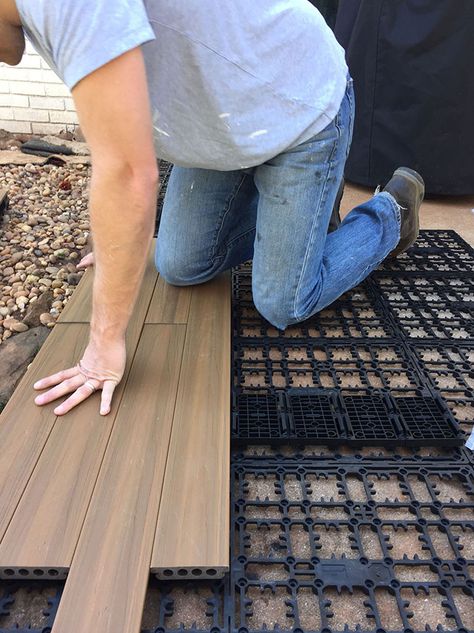 A person snapping in deck boards over a concrete patio. Poured Concrete Patio, Diy Concrete Patio, Pavers Diy, Concrete Patio Makeover, Backyard Covered Patios, Easy Patio, Deck Flooring, Cement Patio, Diy Backyard Patio