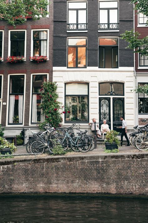 Old couple sitting in front of their canal house in Amsterdam with bikes and beautiful red roses across facade. Canal House Amsterdam, Amsterdam Canal Houses, Slow Summer, Amsterdam Canals, Canal House, Romantic Evening, Summer Evening, Get Over It, Red Roses