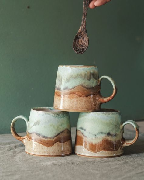 Three medium pottery mugs glazed in browns and greens to represent a coastal scene Handbuild Pottery Mugs, Mug Forms Pottery, Ceramic Mug Photography, Mug Throwing, Ceramics Mugs Handmade, Glazing Mugs Ideas, Potter Glaze Ideas, Hand Painting Pottery, Cute Mugs Pottery