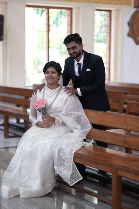 The bride in her exquisite Kerala wedding attire gracefully adorns a pristine white organza saree paired with a regal high-neck blouse, further enhanced by the timeless allure of full sleeves. Kerala Christian Wedding, Christian Couple, Christian Couples, 21st Birthday Photoshoot, Wedding Look, Christian Wedding, Birthday Photoshoot, Wedding Looks, 21st Birthday