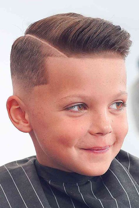 Some younger kids have what we call baby hair at the front. This normally grows into your son’s hair eventually or disappears. Sometimes we need to include it in style by lining it in, as is shown in this skin fade with a hard side part. His hair has been taken down to the skin and faded up at the midpoint. This then leaves enough hair to line in the temples and the fringe. The parting has been edged in and then razored to make the part stand out more. Back To School Haircuts For Boys, Trending Boys Haircuts, Haircuts For School, Kid Boy Haircuts, Hard Part Haircut, Kids Hairstyles Boys