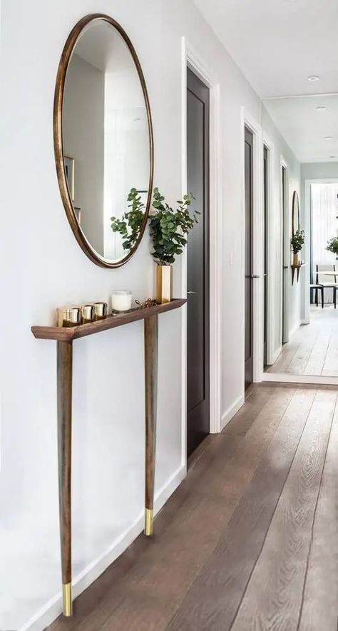 A contemporary entryway with a super sleek console with brass legs, brass jar candles and a vase, a round mirror in a brass frame is cool Sleek Console, Contemporary Entryway, Brass Legs, Jar Candles, Entry Way, Brass Frame, Round Mirrors, Decoration Design, Home Decor Ideas