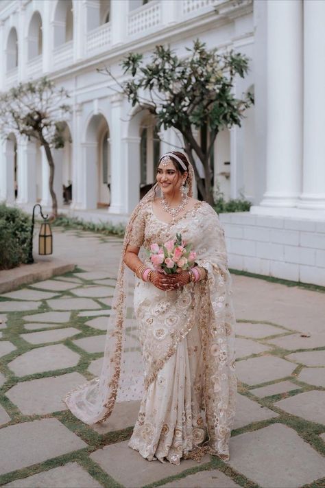 A Sabyasachi Mukherjee lehenga is bridal royalty at a wedding. The craftsmanship and the intricate detailing are a work of art. And that extends to Sabyasachi’s entire collection. For brides who aren’t fans of lehengas but love his work, you can still don a Sabya outfit for your wedding! We picked up 10 fabulous outfits that are made by the genius himself but aren’t lehengas. From gowns and sarees to stunning jackets, this list has it all. Sabyasachi White Saree, Ivory Wedding Saree, Modern Bridal Saree, White Saree Bridal Look, White Saree Wedding Bridal, Indian Bridal Saree Look, Sabyasachi Sarees Brides, Reception Bride Look, White Indian Bride