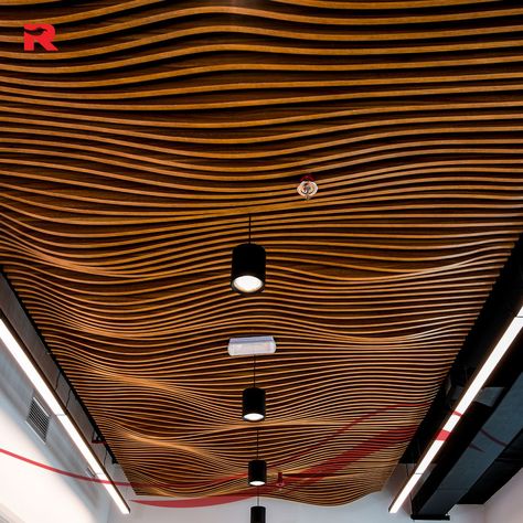 Look up and get inspired! Our parametric ceiling design for the Advanced Systems office is a modern example of innovative thinking & excellent craftsmanship. It stands out for its undulating, wave-like wooden design, which creates a dynamic and eye-catching focal point. The intricate pattern creates a feeling of movement and architectural interest, while the modern light fixtures on the ceiling improve the overall appeal of the space. Ready to transform your space? 🔗 Click the link in our... Wavy Ceiling Design, Wave Ceiling, Wave Ceiling Design, Wave Ceiling Design Interiors, Parametric Ceiling Design, Parametric Ceiling, Parametric False Ceiling, Wood Slat Ceiling, Parametric Design